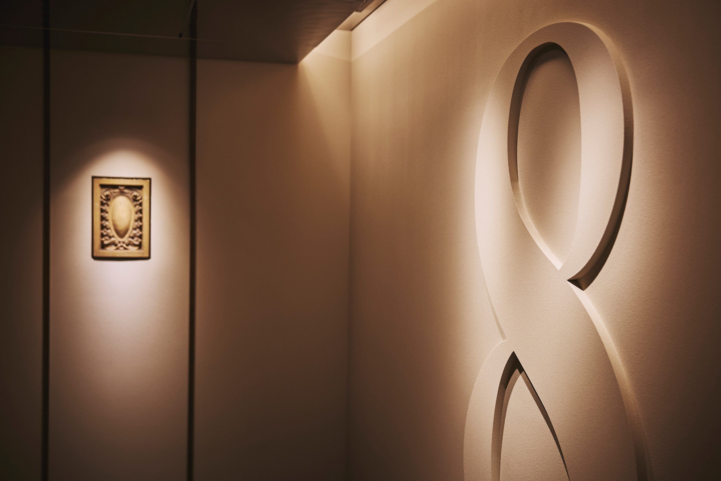 Un mur orné d’un grand chiffre « 2 » lumineux et d’un tableau encadré qui y est accroché.