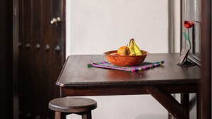 A wooden table with a bowl of fruit and a colorful cloth. - Loft El Chiquito (Antigua Guatemala)