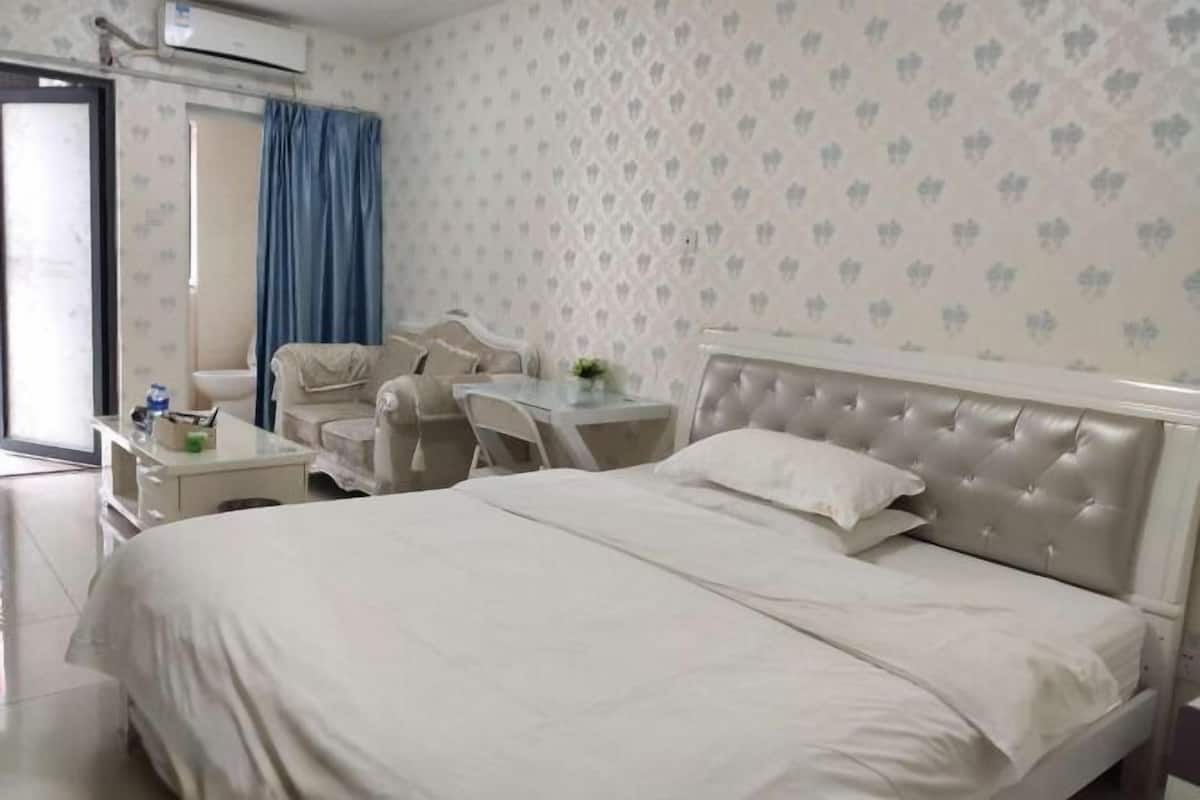 Una habitación de hotel con una cama, un escritorio, una silla y una mesita.