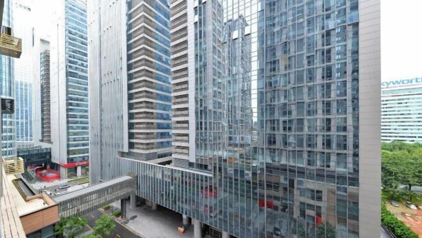A modern high-rise building with a glass facade, multiple floors, and a central courtyard. - Tiantianhui Apartment Hotel (Shenzhen)