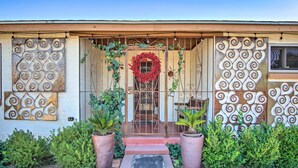 A house with a decorative front door, a red wreath, and patterned wall designs. - Tucson House w/ Private Pool: 5 Mi to Downtown! (Tucson)