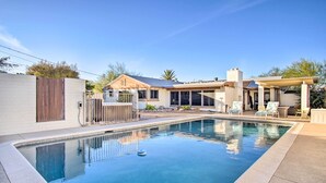 A swimming pool with a clear blue water surface, surrounded by a patio area with lounge chairs and a covered seating area. - Tucson House w/ Private Pool: 5 Mi to Downtown! (Tucson)
