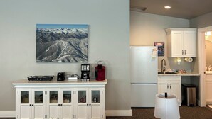 A compact kitchen with a refrigerator, a coffee maker, and a microwave on the counter.