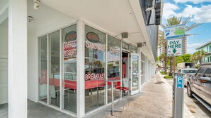 A storefront with signs for coffee, dessert, and breakfast. - Purple Pelican by Opus (Suite 1) (Fort Lauderdale)