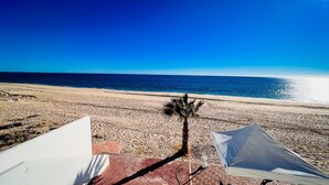 Blick auf einen Strand mit einer Palme und Zelten.