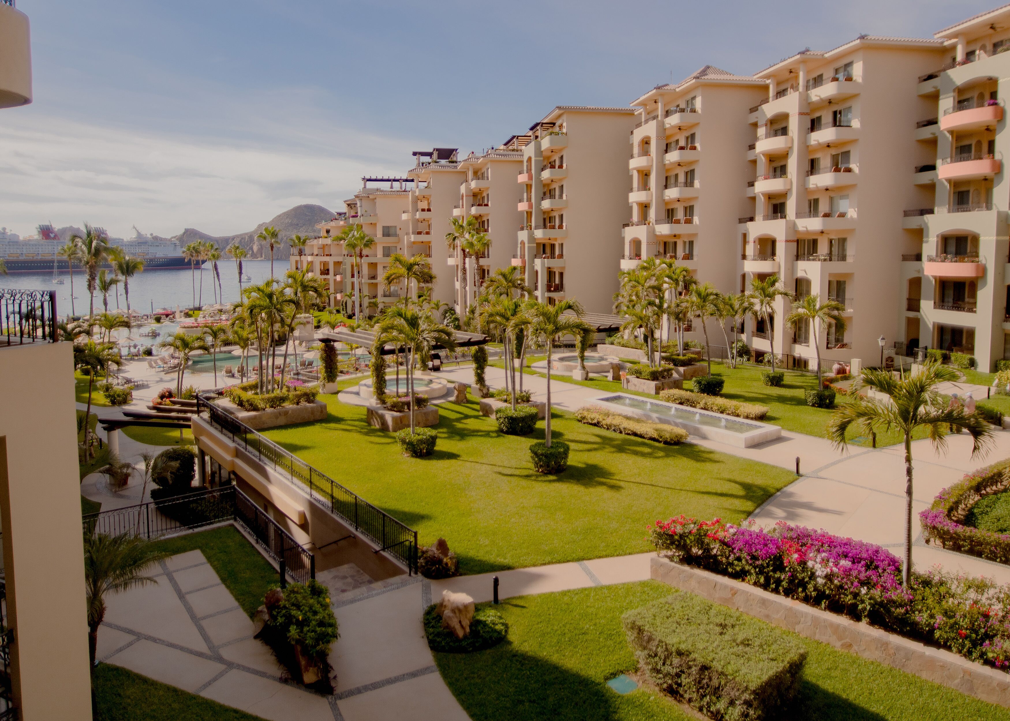 A resort with multiple buildings, a swimming pool, and well-maintained gardens.