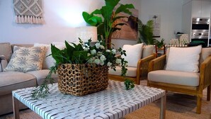 A living room with a woven coffee table, cushioned chairs, and a large plant. - 3 Bedroom Oasis with Private Pool (Casuarina)