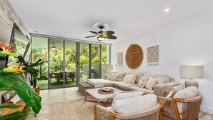 A modern living room with a beige sofa, wicker chairs, a coffee table, and a ceiling fan. - 3 Bedroom Oasis with Private Pool (Casuarina)