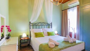 A bedroom with a bed, bedside table, lamp, and a window with curtains.