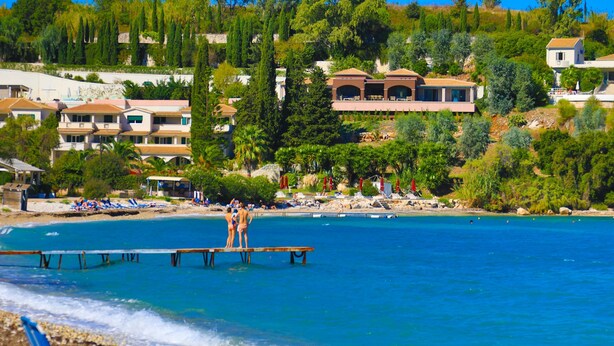 A coastal area with a pier, beach, and residential buildings.
