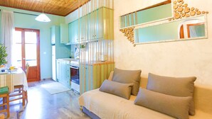 A cozy room with a bed, a dining table, and a kitchen area.