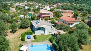 Un quartier résidentiel avec des maisons, une piscine et un paysage vallonné en arrière-plan.