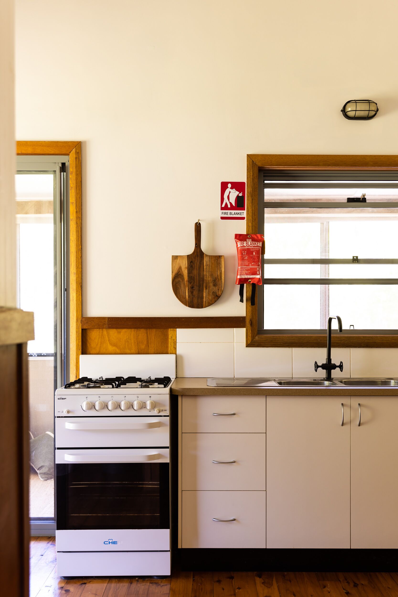 Une cuisine équipée d’une cuisinière, d’un four, d’un évier et de meubles de rangement en bois.