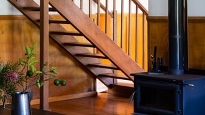 Una escalera de madera con un horno de leña negro.
