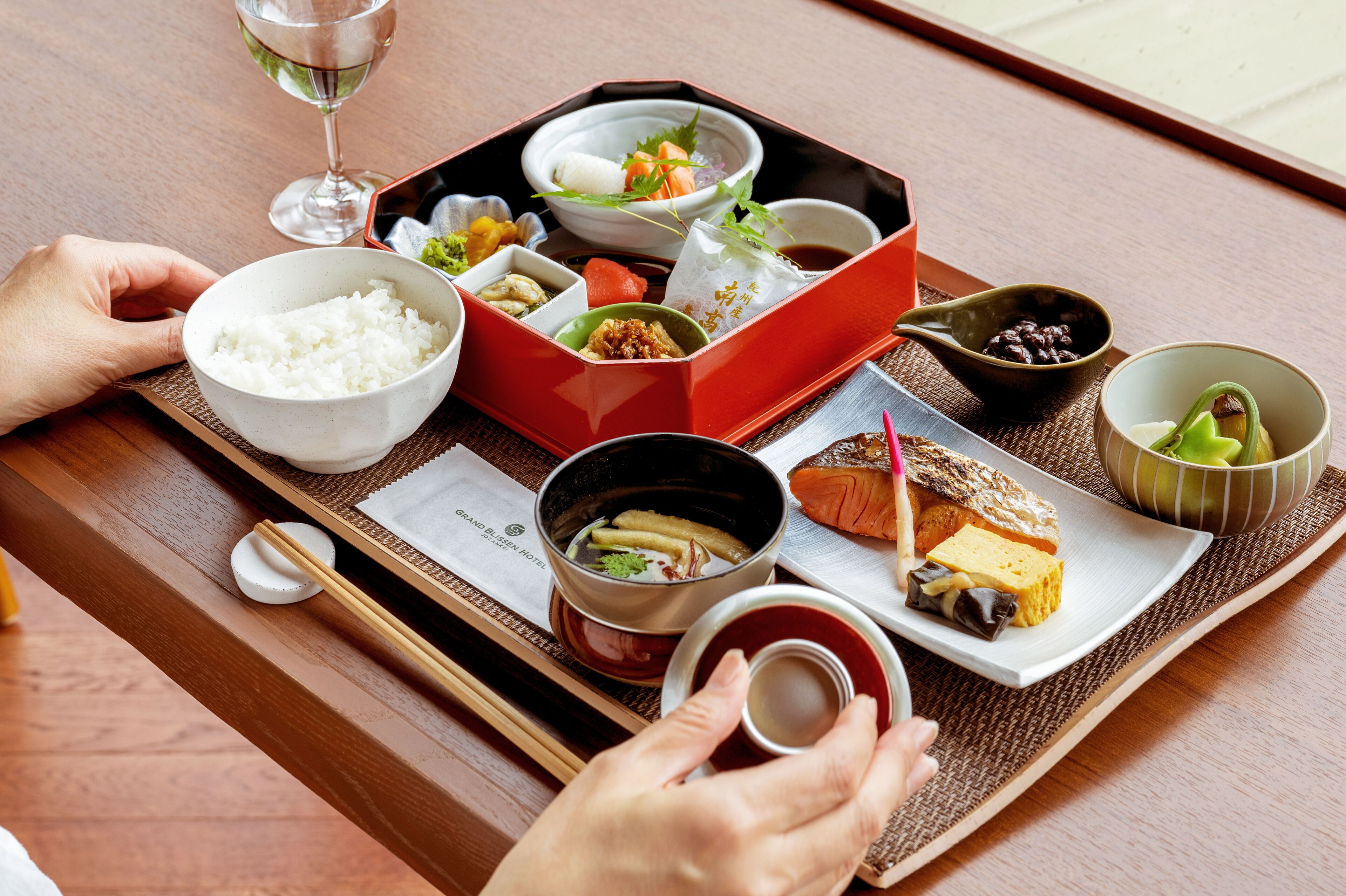Een traditionele Japanse maaltijdopstelling met rijst, soep en diverse bijgerechten op een dienblad.