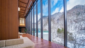 Un interior moderno con ventanas amplias que ofrecen vistas a un paisaje nevado de montaña.
