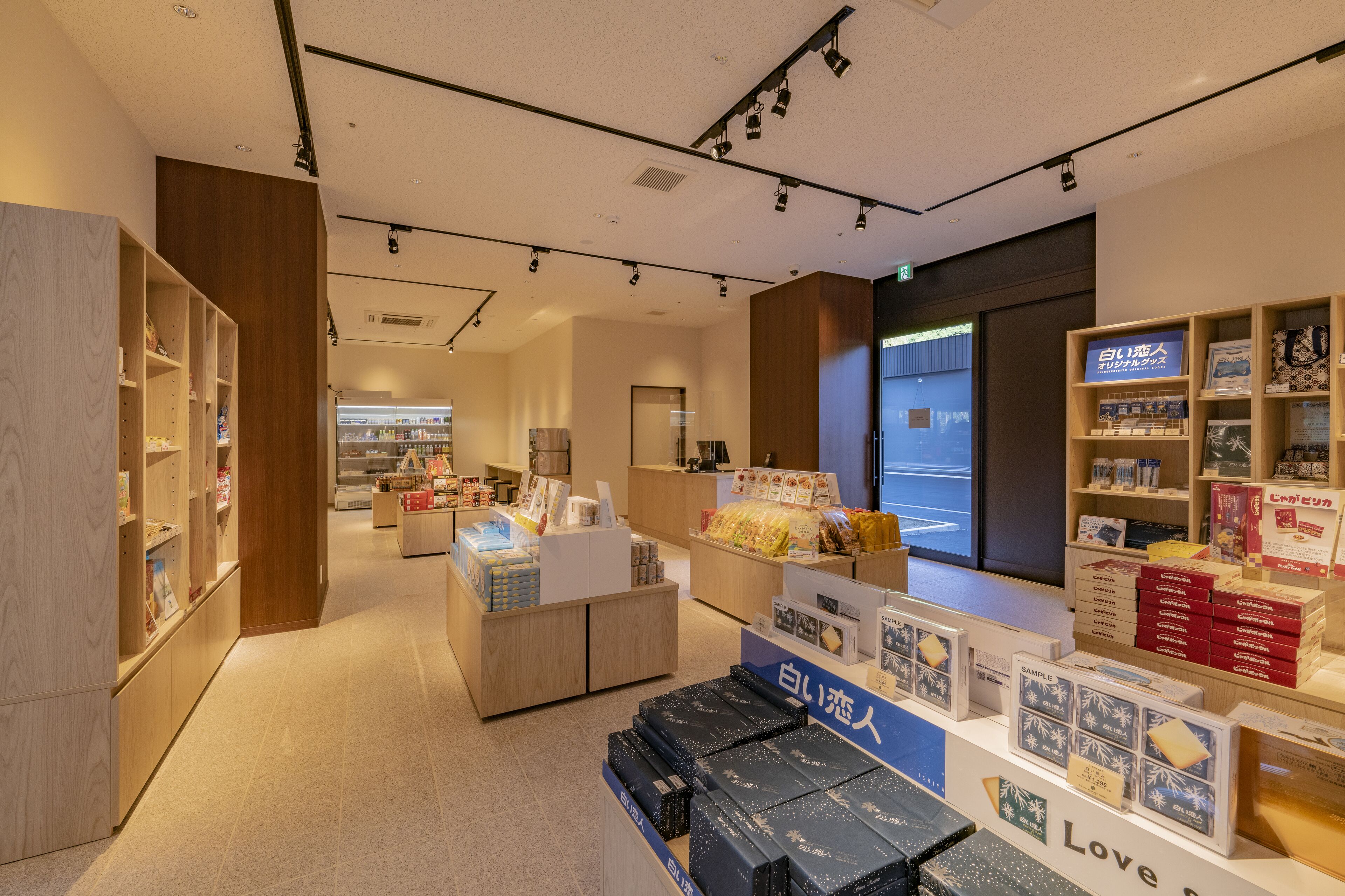 A modern retail store with wooden shelves and display tables.
