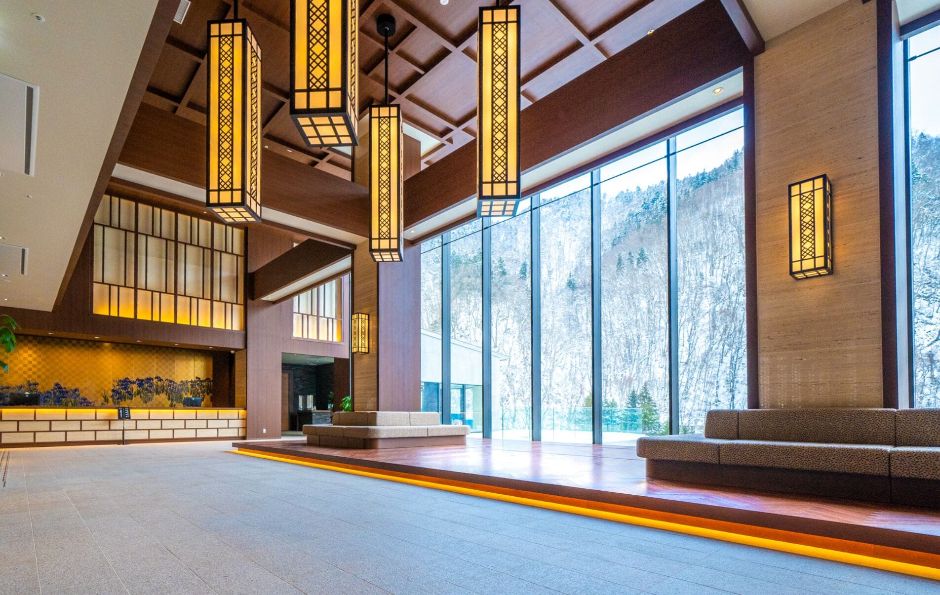 A spacious lobby with large windows, a reception desk, and modern lighting fixtures.
