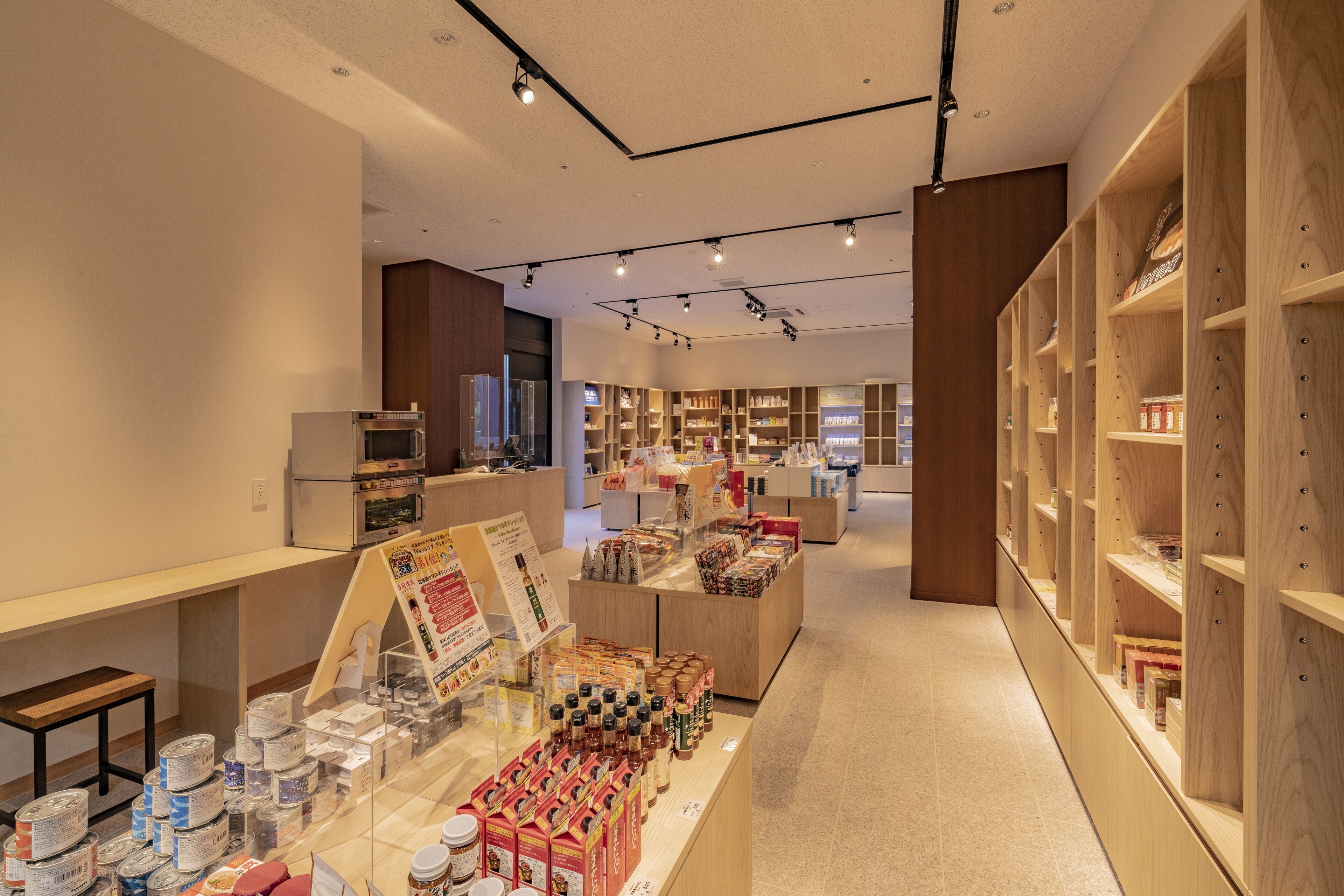 A modern retail store with wooden shelving, a central display area, and a clean, well-lit interior.