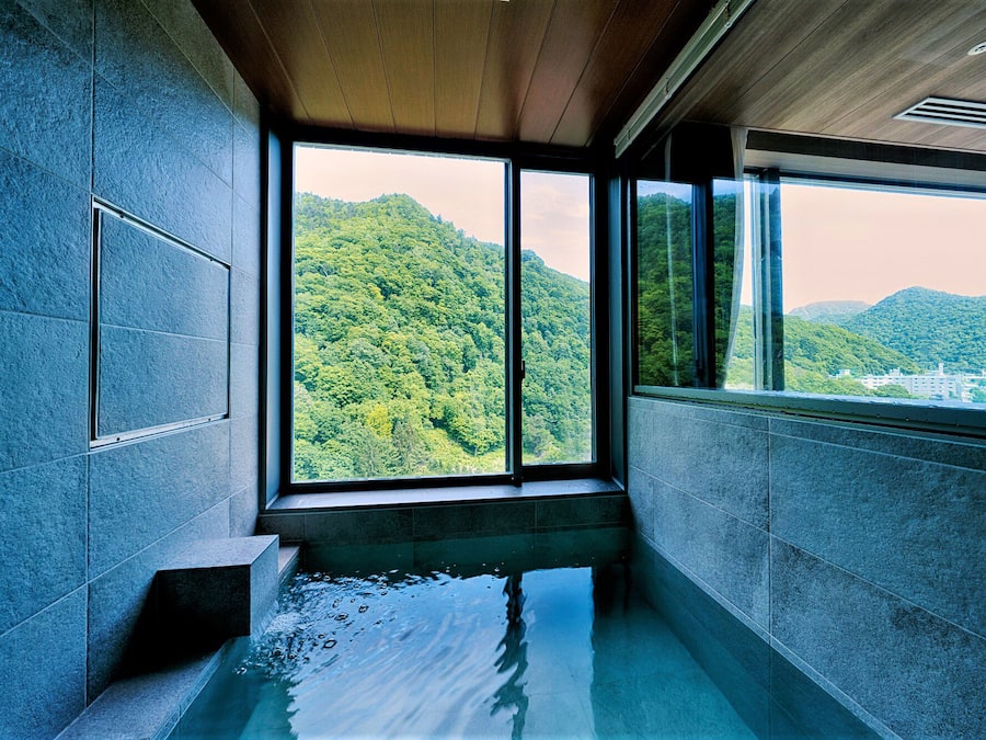 Een bad/douchecombinatie, een bronwaterbad, badjassen