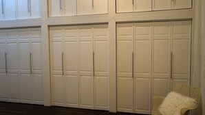 A row of white double doors with handles, likely leading to a storage or utility area.