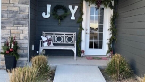 A front porch with a bench, a wreath above the door, and a 'JOY' sign. - Spacious new home with a country feel. (Kearney)