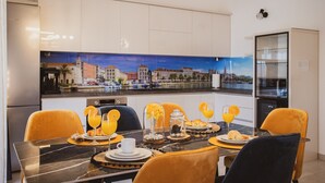 A modern dining area with a marble table, yellow chairs, and a cityscape mural on the wall. - A2 - luxury apt w terrace, gym, jacuzzi & sauna (Dugi Rat)