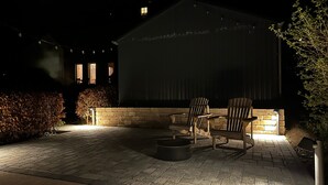 Un patio con mobiliario exterior y un edificio al fondo.
