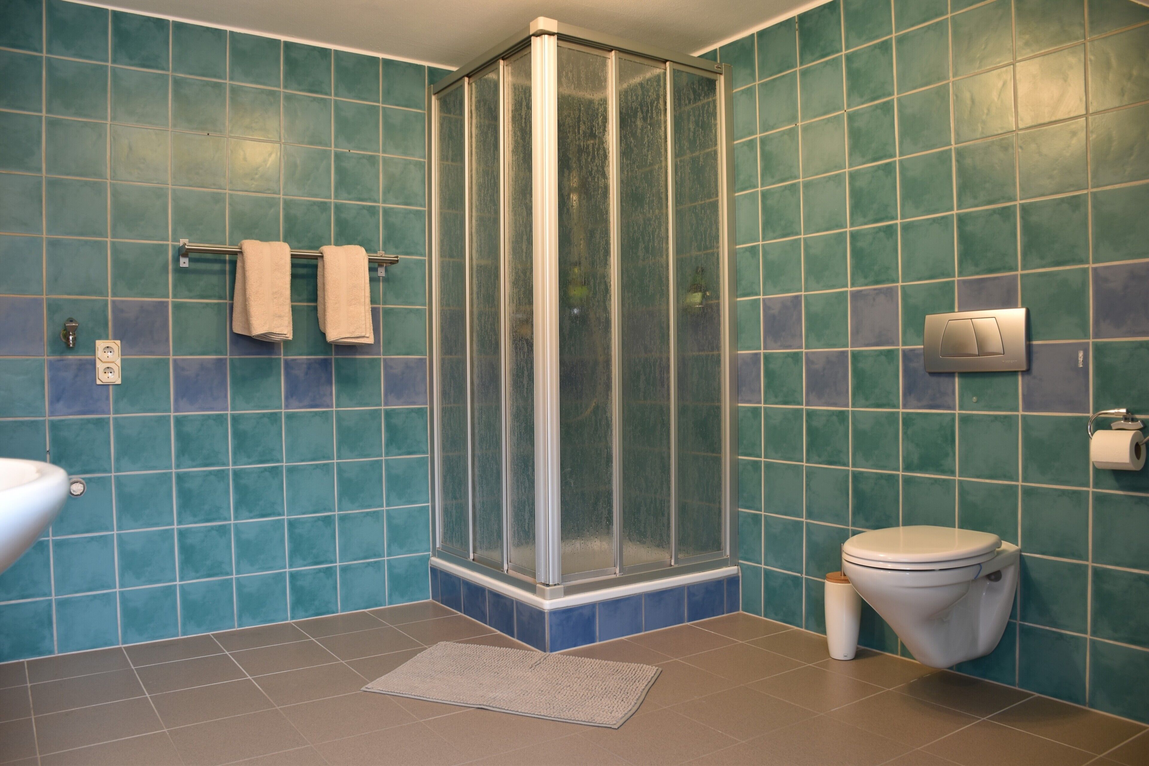 Ein Badezimmer mit Duschkabine, Toilette und Waschbecken.