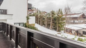 A balcony with a view of a snowy landscape, a wooden deck, and a building with a white facade. - Holiday Apartment "Haus Excelsior Top 5" with Mountain View, Balcony and Wi-Fi (Seefeld in Tirol)
