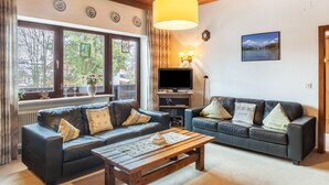 A living room with two sofas, a coffee table, a TV, and a large window. - Holiday Apartment "Haus Excelsior Top 5" with Mountain View, Balcony and Wi-Fi (Seefeld in Tirol)