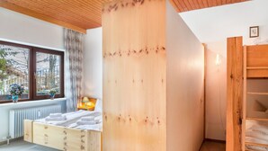 A bedroom with a wooden bed, a window with a view, and a wooden wardrobe. - Holiday Apartment "Haus Excelsior Top 5" with Mountain View, Balcony and Wi-Fi (Seefeld in Tirol)