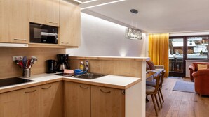 Una cocina moderna con gabinetes de madera, microondas integrado y cafetera.