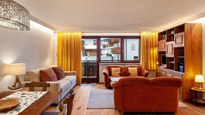 Una sala de estar moderna con un sofá, un sillón, una mesa de comedor y un mueble de madera.