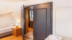 A bedroom with a bed, bedside table, lamp, and a wardrobe. - Holiday Apartment "Haus Excelsior Top 37b" with Mountain View, Balcony & Wi-Fi (Seefeld in Tirol)