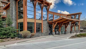 A modern building with large windows and a stone facade. - Luxury Hotel Room Free Parking, Pool &Hot Tub (Canmore)