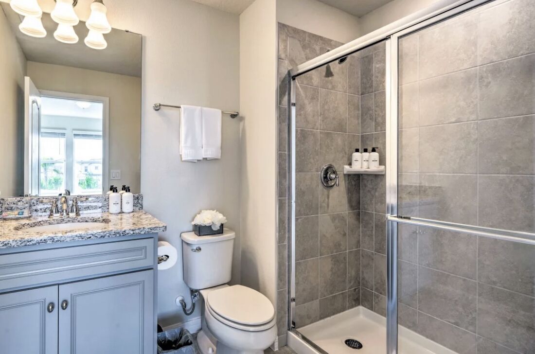 A modern bathroom with a shower, toilet, and vanity.