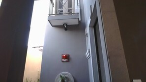 A building facade with a fire alarm, a small window, and a door. - BELLAS VILLAS VILLA AMOR HERMOSA CASA y ACCECIBLE PRECIO (San Miguel de Allende)