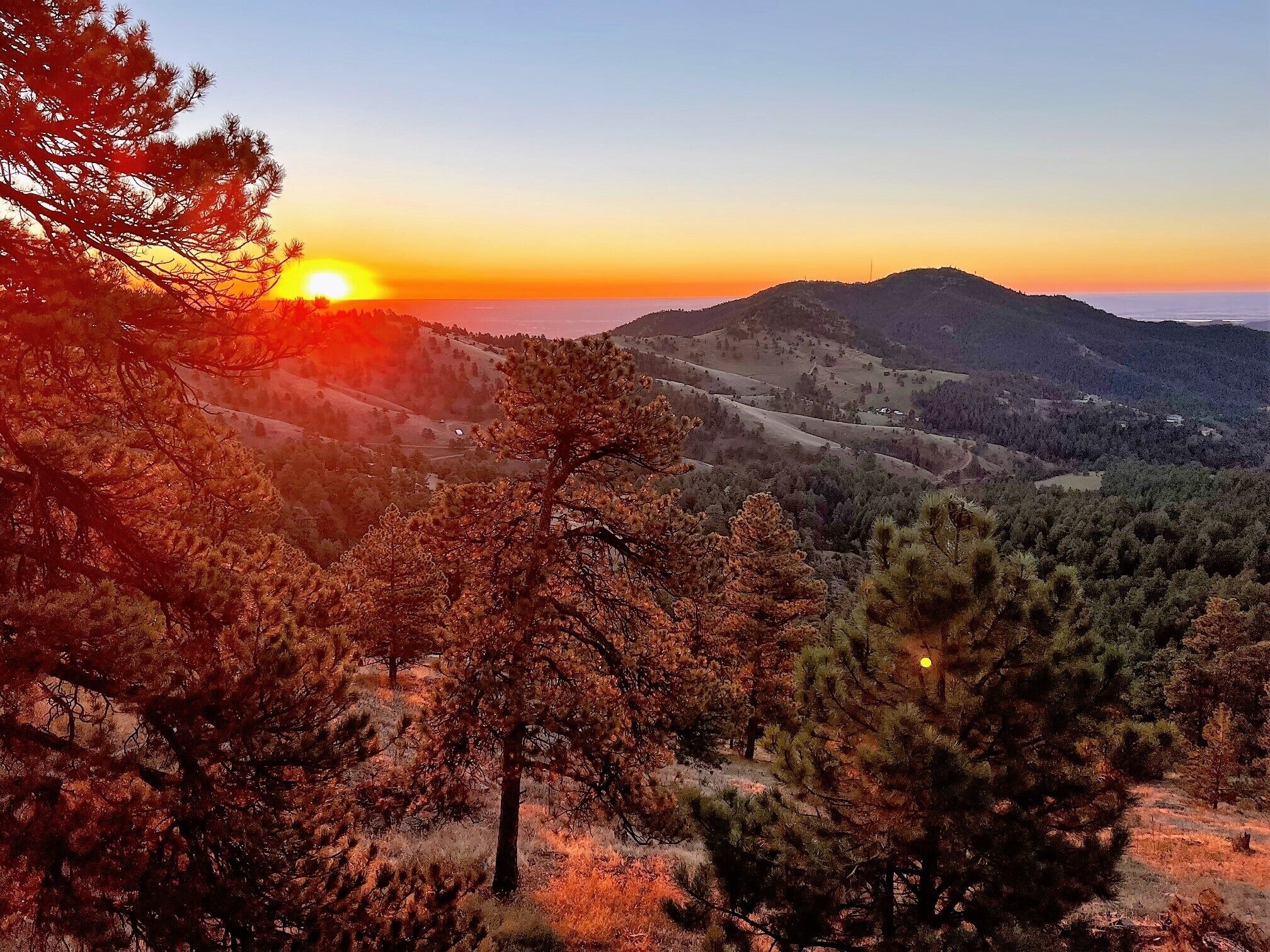 Eine gebirgige Landschaft bei Sonnenuntergang.