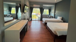 Habitación de hotel con dos camas, un escritorio, una silla, un televisor y un balcón con cortinas.