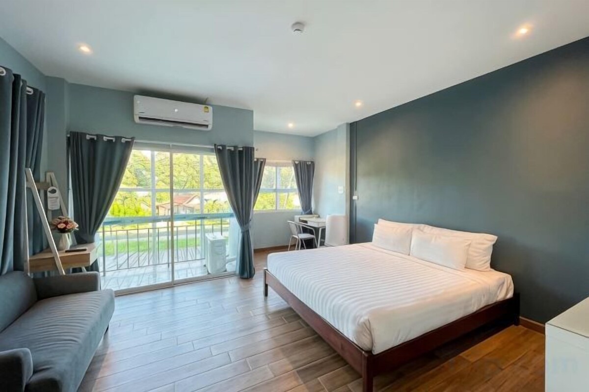 A bedroom with a bed, a desk, and a chair.