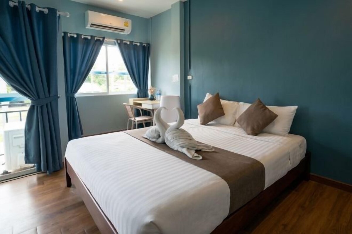 A hotel room with a bed, a desk, and a chair.