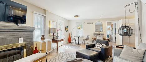 Télévision, cheminée, lecteur de DVD, livres