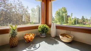 A kitchen counter with a pineapple, a bowl of oranges, a potted plant, and a bowl of fruit. - Gather your family in Montana for outdoor fun and memories. (Kalispell)