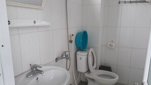 A small, clean bathroom with a sink, toilet, and shower. - Nha Nghi Hung Van - Bac Kan (Duc Xuan)