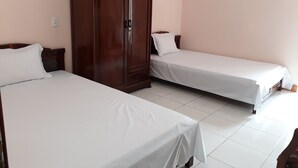 A room with two single beds, a wooden wardrobe, and a tiled floor. - Nha Nghi Hung Van - Bac Kan (Duc Xuan)