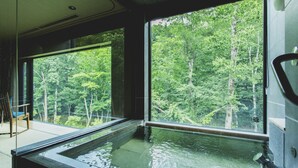 A room with a large window overlooking a forest, a wooden chair, and a small pool. - Okujozankeionsen Kashogyoen (Sapporo)