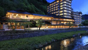 A multi-story hotel with a traditional Japanese architectural style, featuring a large building with multiple balconies and a smaller adjacent structure with a tiled roof. - bankokuya (Tsuruoka)