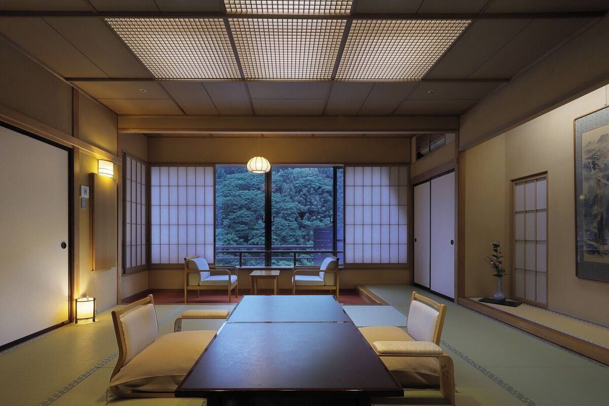 A traditional Japanese room with tatami flooring, a low table, and sliding doors.