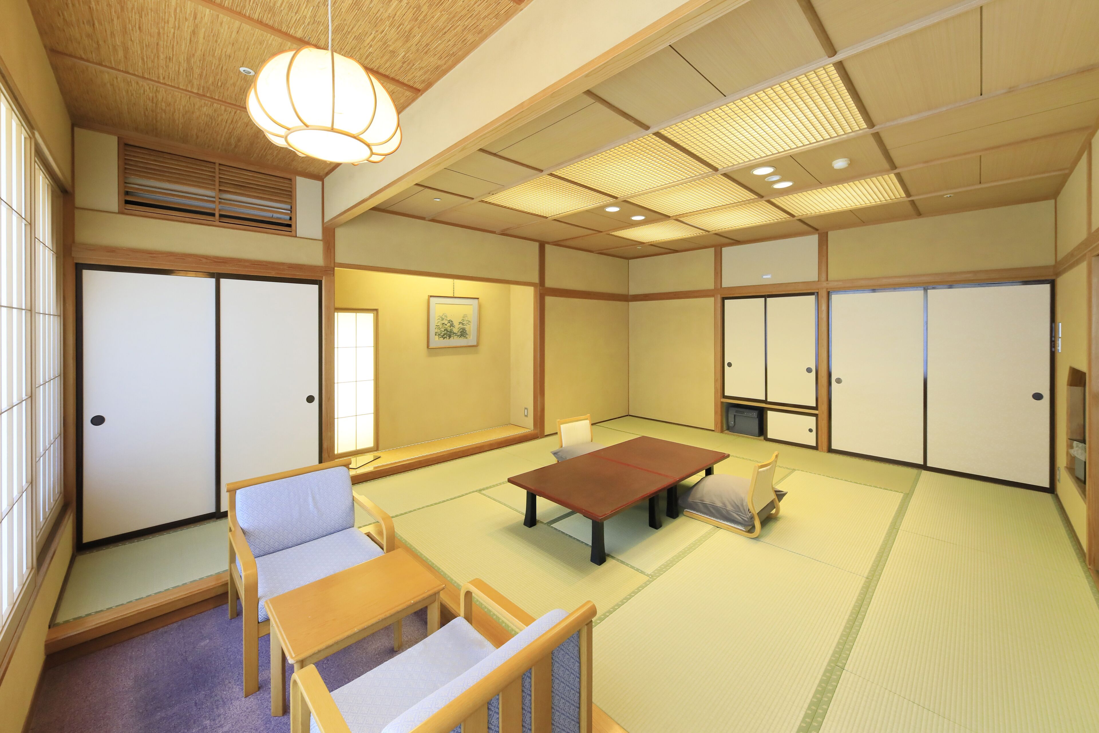 Une pièce de style japonais traditionnel, avec un sol recouvert de tatamis, une table basse et un canapé.